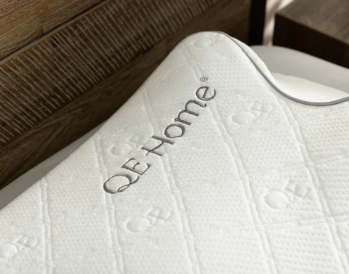 Close-up of the breathable bamboo blend cover and embroidered QE Home logo on our Butterfly Memory Foam Pillow.