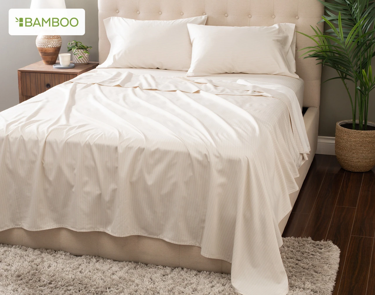 Angled view of our Bamboo Cotton Sheet Set in Sandy Stripe dressing a bed in a simple bedroom.