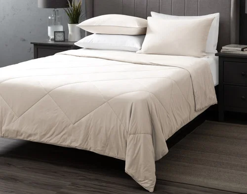 Our Cloudstone Cool Touch Blanket dressed over a white bed with coordinating pillowcases.