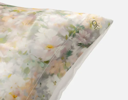 Close-up on the embroidered QE Home logo on the corner of our Mulberry Silk Pillowcase in Ruthana.