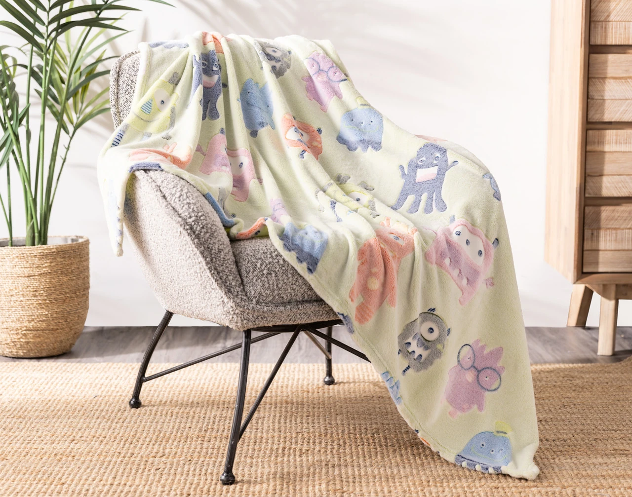Angled view of our Snuggle Monsters Glow In The Dark Throw draped over a chair.