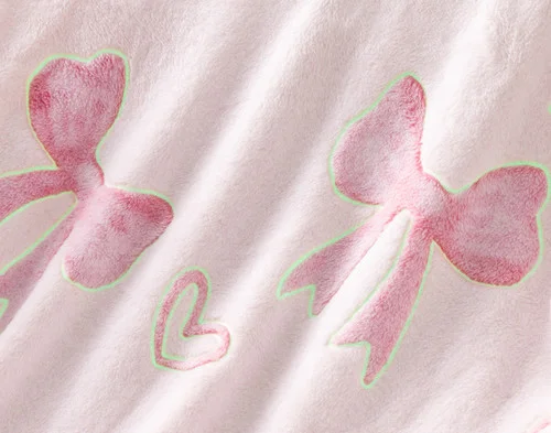 Close-up on the etched designs on our Bows & Hearts Glow In The Dark Throw with outlines to show its glowing spots.