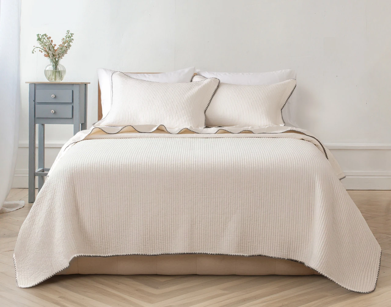Our Ines Quilt Set dressing a queen bed in a simple bedroom.