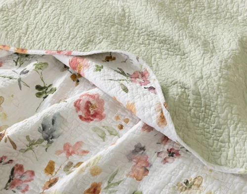 Close-up of the floral surface and sage green reverse on our Rosalia Cotton Quilt Set.