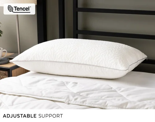 Our Deep Sleep Shredded Memory Foam & Lyocell Pillow lying atop a bed.