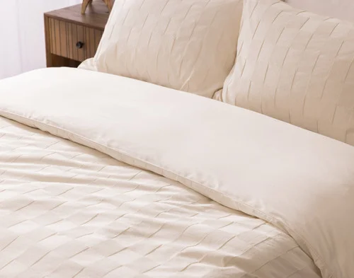 Angled view of our Obrigado Duvet Cover Set dressing the head of a bed.