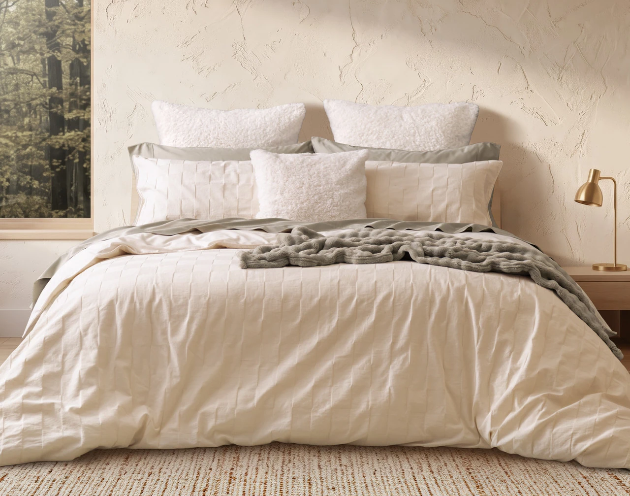 Front view of our Obrigado Duvet Cover Set dressing a queen bed with accessories.