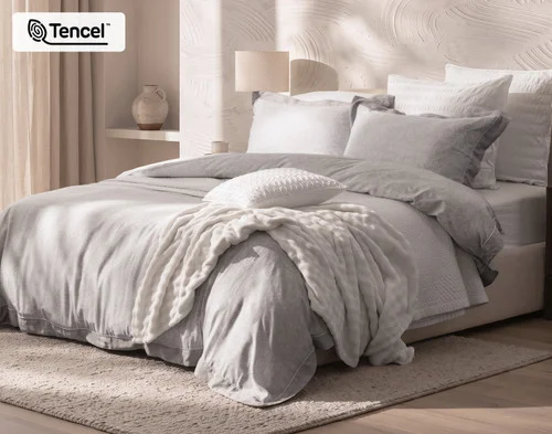 Angled view of our Sterling Duvet Cover dressing a queen bed with accessories.