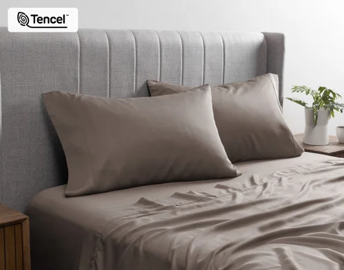 Front view of our BeechBliss TENCEL™ Modal Pillowcases in Bark resting against a headboard in a bed with matching sheets.