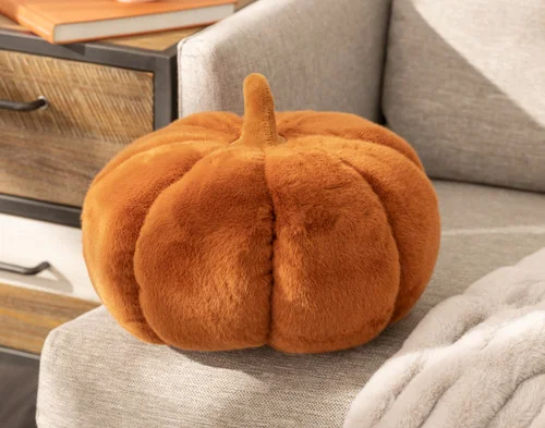 Angled view of our Pumpkin Cushion in Copper sitting politely on a beige couch.