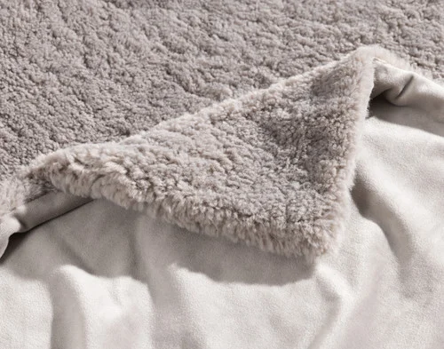 Folded corner of our Ashwood Poodle Faux Fur Throw to show its front and reverse sides.