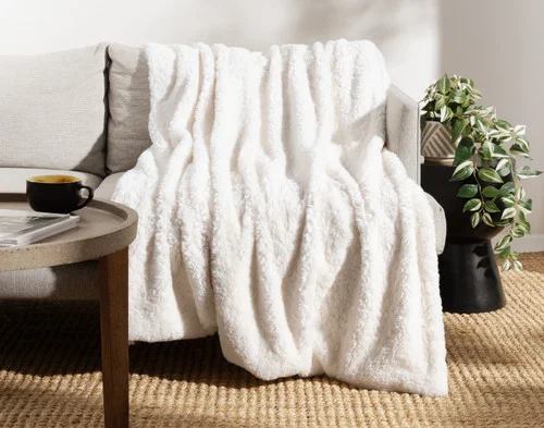 Front view of our Ivory Poodle Faux Fur Throw draped over a couch.