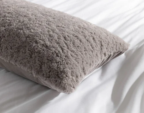 Close-up of the edges on the corner of our Ashwood Poodle Faux Fur Lumbar Pillow.