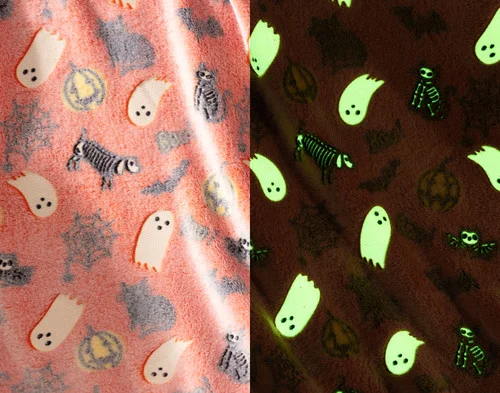 Side-by-side view of the soft fleece surface of our Boo & Bones Glow in the Dark Fleece Throw in the light and while glowing in the dark.