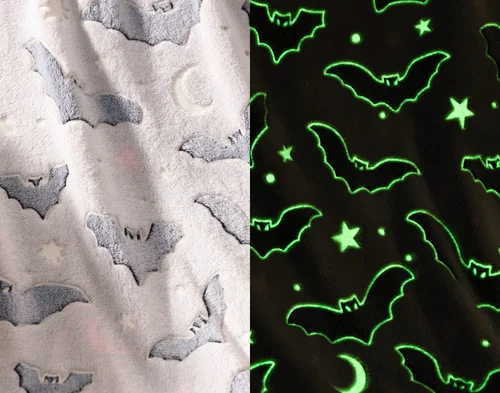 Side-by-side view of the soft fleece surface of our Midnight Bats Glow in the Dark Fleece Throw in the light and while glowing in the dark.