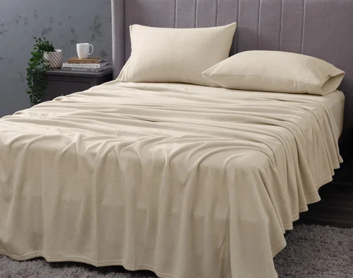 Angled view of our Cuddle Fleece Sheet Set in Oakwood fitted over a queen bed in a dark grey bedroom.