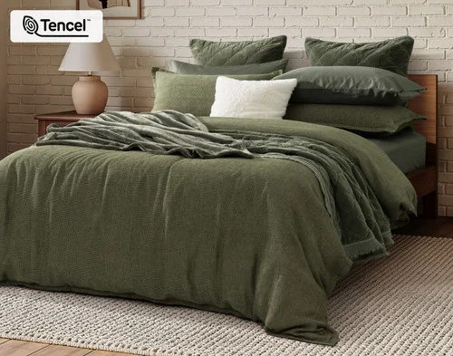 Angled view of our Greenwood Duvet Cover dressed on a queen bed with accessories.