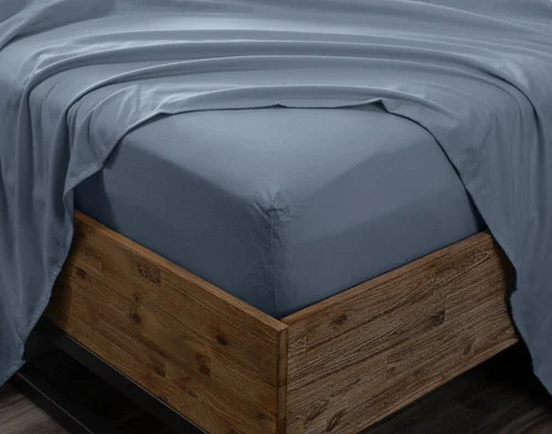 Angled view of the corner on a mattress wrapped in our Arctic Slate Flannel Sheet Set.