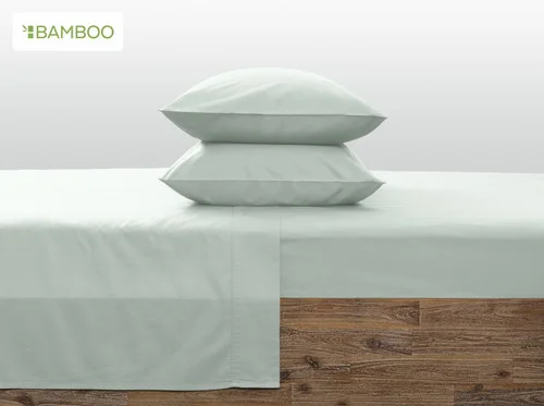 Our Bamboo Cotton Pillowcases in Aqua Smoke resting symmetrically on a wooden bed.