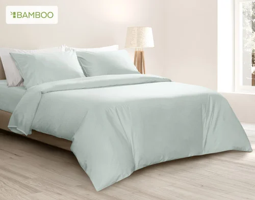 Angled view of our Bamboo Cotton Duvet Cover in Aqua Smoke draped over a queen bed in a white bedroom.