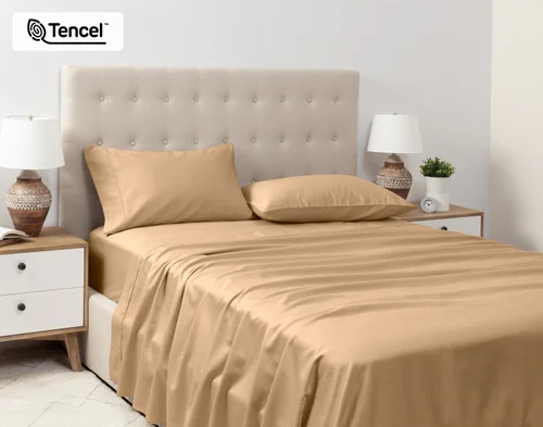 Angled view of a queen bed dressed in our Eucalyptus Luxe Sheet Set in Sandalwood.