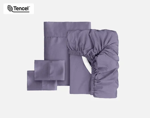 The full contents of our Eucalyptus Luxe Sheet Set in Purple Basil sitting against a solid background, including a fitted sheet, flat sheet, and two pillowcases.