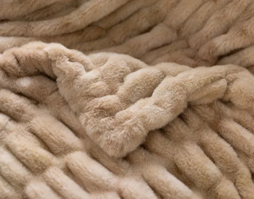 Close up on the folded surface of our Cocoon Plush Throw in Caramel to show its textured surface.