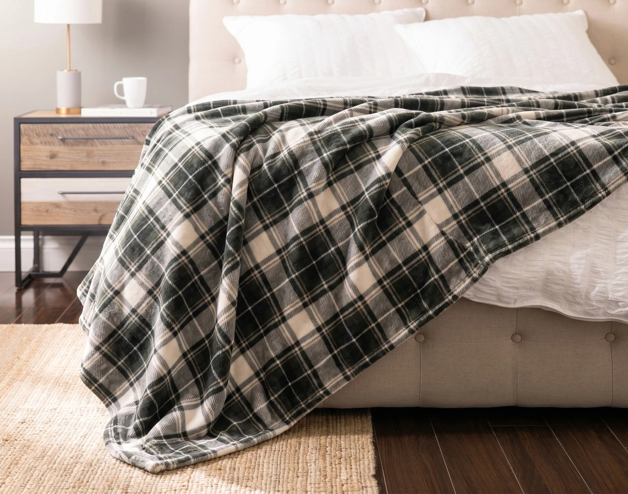 Front view of our Pine Plaid Blanket draped over a white bed.