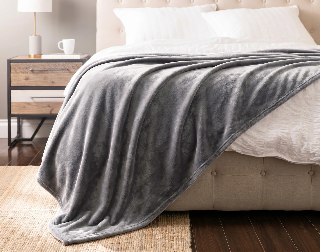 Front view of our Shark Cashmere Touch Blanket draped over a white bed.