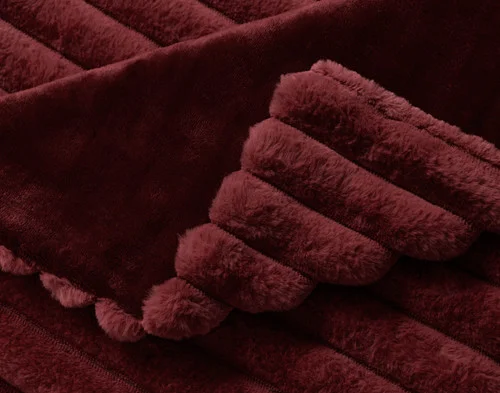 Close up on the folded surface of our Channel Plush Throw - Mulled Wine.