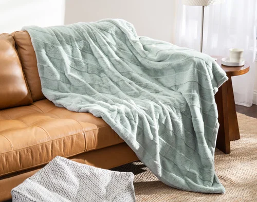 Our Etched Check Throw - Silver Sage draped on a brown couch.