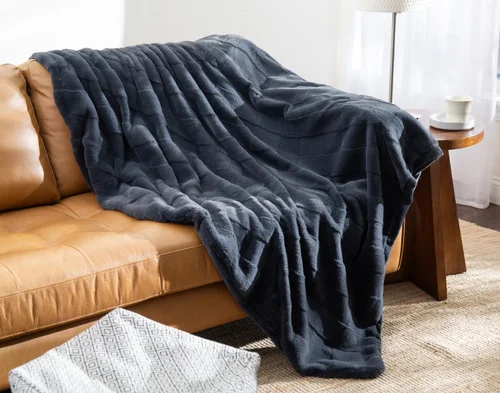 Our Etched Check Throw - Night Tide draped on a brown couch.