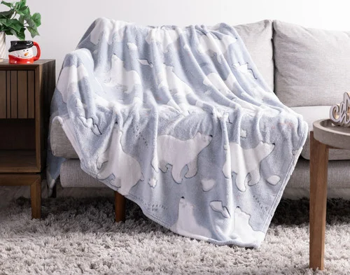 Our Polar Cove Glow in the Dark Throw draped over a couch.