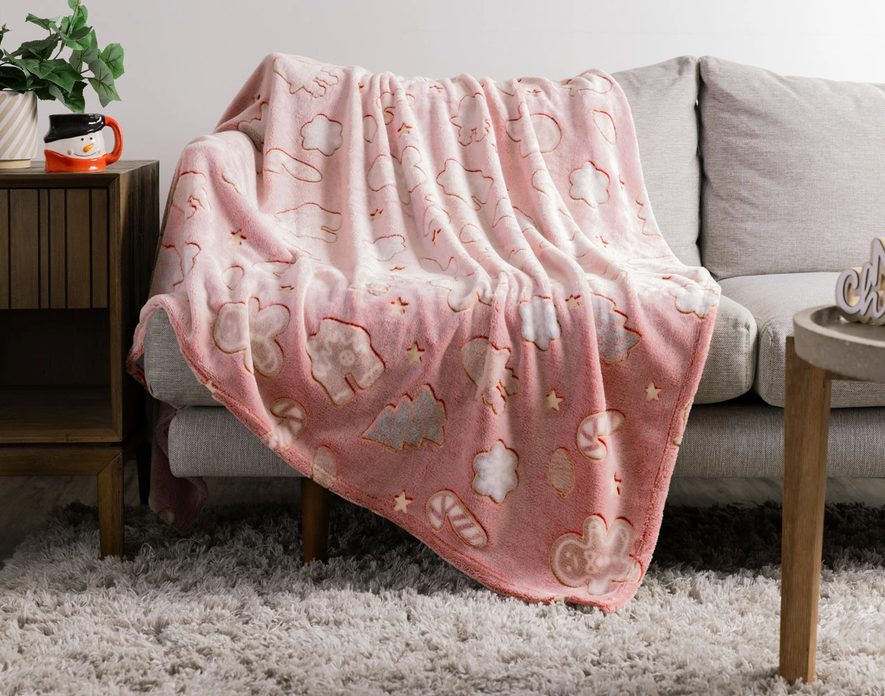 Our Holiday Huddle Glow in the Dark Throw draped over a couch.