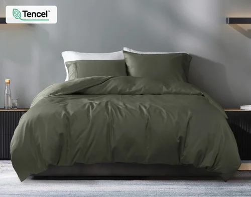 Our Eucalyptus Luxe Duvet Cover in Bonsai Green dressing a bed in a grey bedroom.