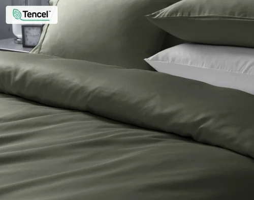 Closer view of our Eucalyptus Luxe Duvet Cover in Bonsai Green dressing the head of a bed.