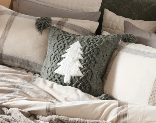 Our Snowpine Holiday Square Cushion tucked into a cozy flannel bed.