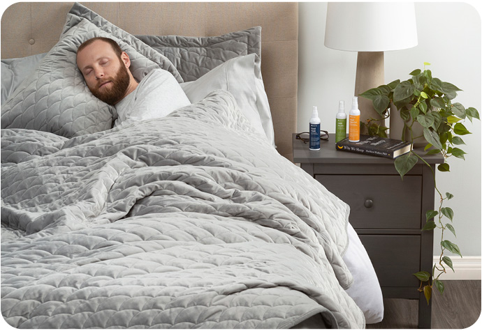 Homme barbu dormant sur un grand lit sous un lit lesté courtepointe ensemble .