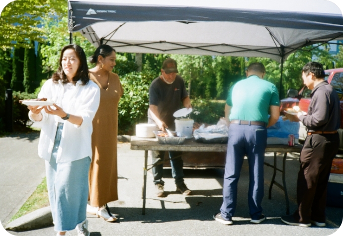 Our Chief Operations Officer and Vice President of Sales positioned near the barbecue area, as staff begin to line up for food.