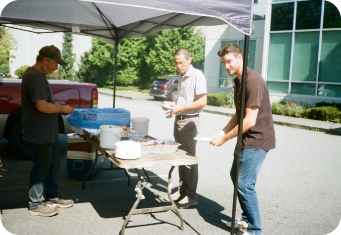 Notre responsable du développement durable fait la queue pour le déjeuner barbecue, face à la caméra, alors qu'ils attendent leur tour.