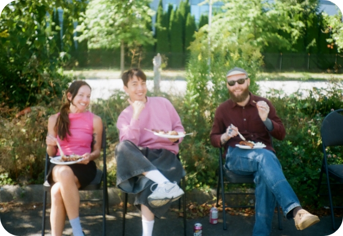 Les membres de notre équipe créative sont assis à une table et prennent leur repas tout en posant pour l'appareil photo.