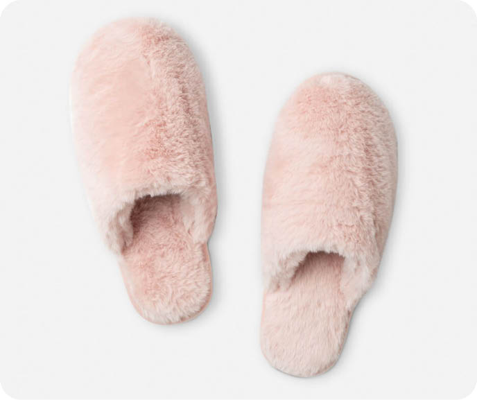Nos pantoufles en fausse fourrure rose blush sont de couleur rose pâle et présentent une surface texturée en fourrure.