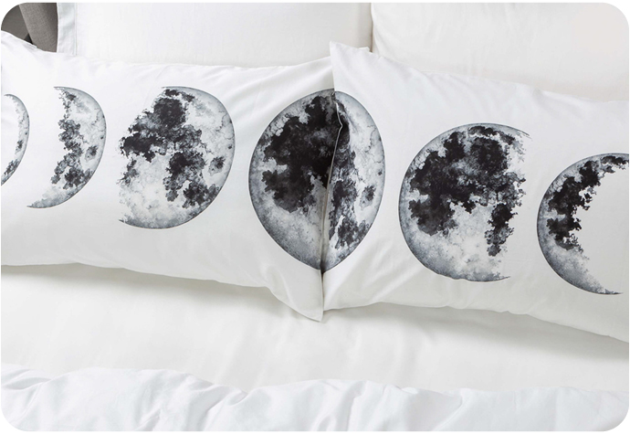 Notre taie d'oreiller Moon Phases Pillow Talk ensemble présente une impression de lune sur du coton blanc.