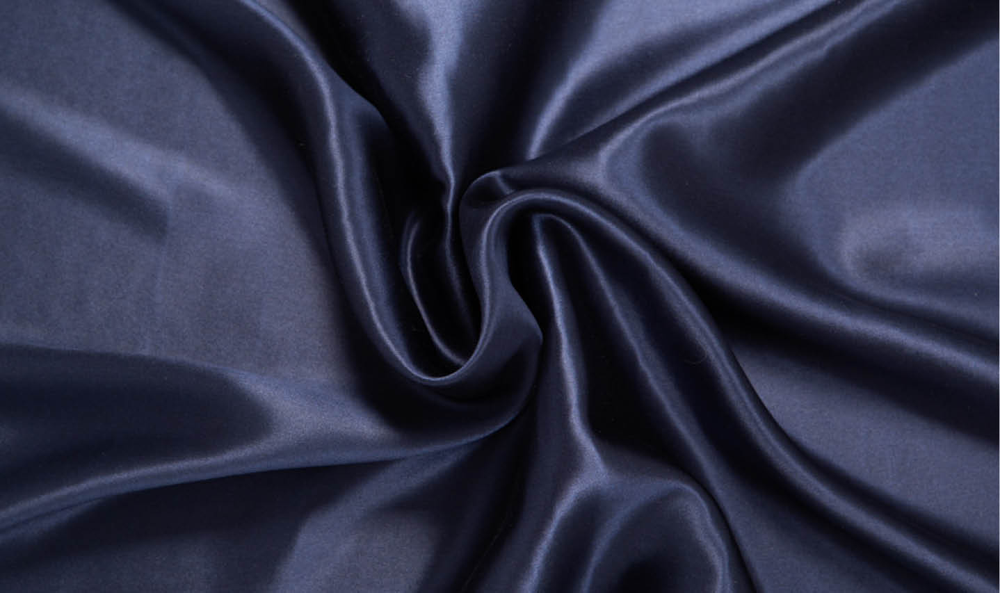 Close-up of our mulberry silk pillowcase in a deep navy blue colour. Close-up of our mulberry silk pillowcase in a deep navy blue colour.