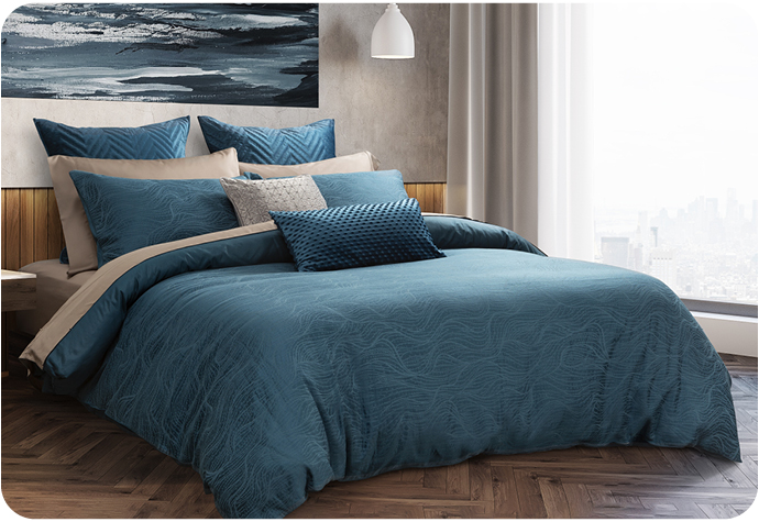 Linge de lit bleu foncé ensemble avec des reflets clairs sur un lit avec une œuvre d'art au-dessus et une fenêtre en vue