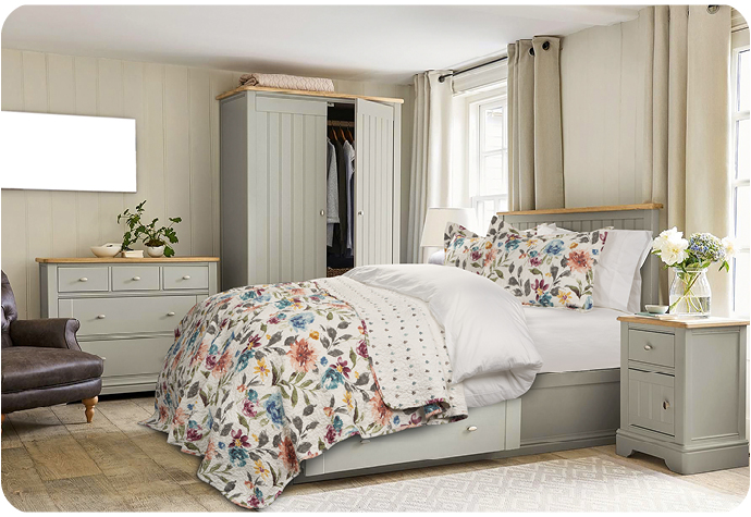 Floral courtepointe ensemble  sur un lit blanc draps dans une chambre avec des meubles gris