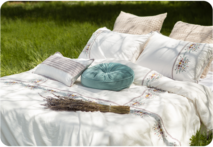 Un élégant lit blanc posé sur l'herbe par une journée très chaude et ensoleillée.