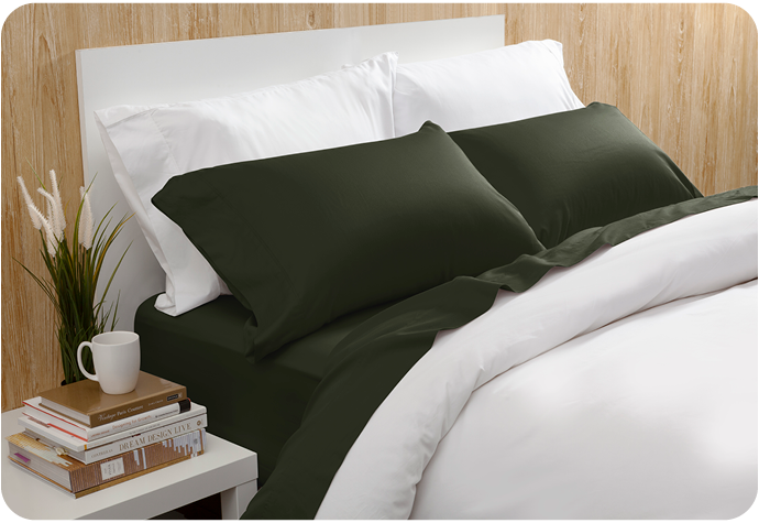 Notre Beechbliss drap ensemble  en Rainforest Green habillé sur un lit blanc dans une chambre à coucher en bois clair.