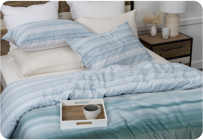 Angled view of our Tidal Bedding Collection dressed over a queen bed, with a small bowl and tray resting on top.
