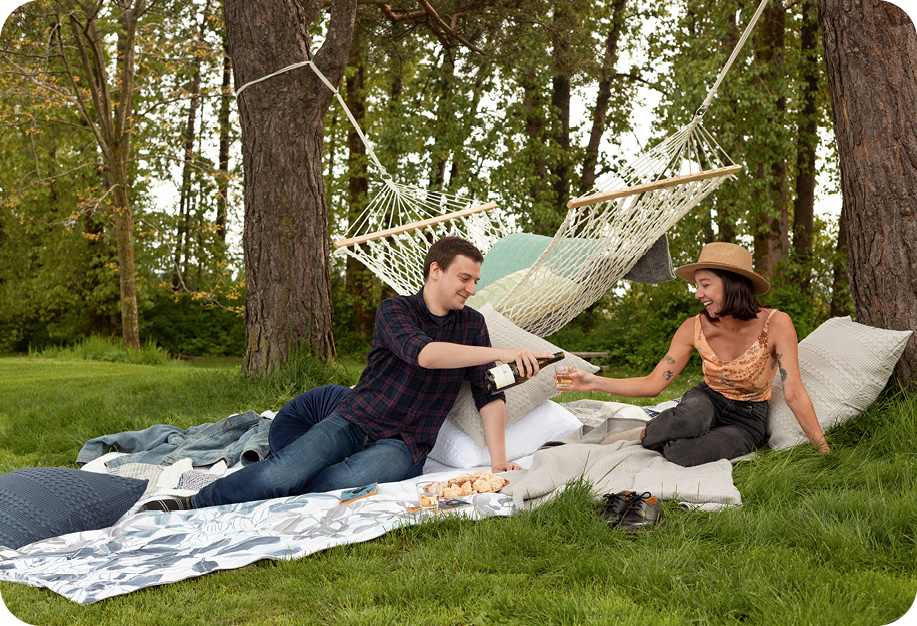 Deux personnes assises à un hamac de pique-nique ensemble sur l'herbe.